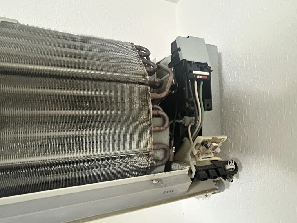 掃除前の汚れたエアコンと電装部